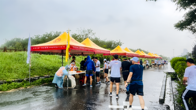 新竹馬拉松陰雨綿綿，永慶加盟四品牌提供的160頂帳篷發揮效果，讓民眾有地方躲雨休憩。(永慶房產集團提供)
