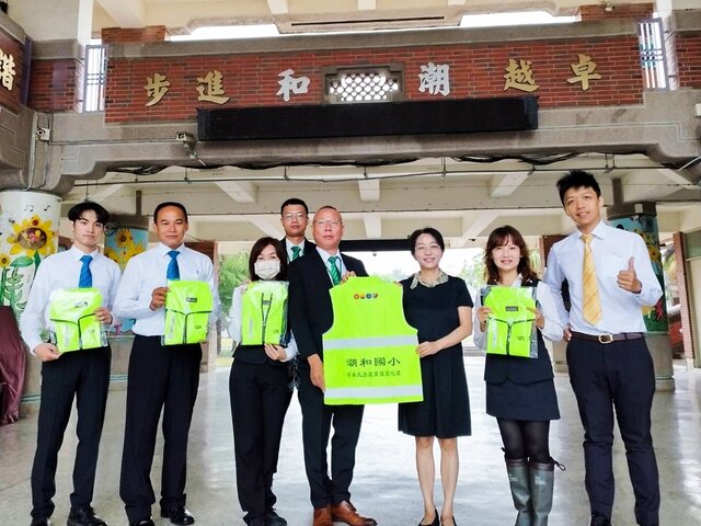 永慶加盟四品牌屏南區聯賣區長曾弘典(圖中)捐贈導護背心給屏東潮和國小，提升校園周邊交通安全。 