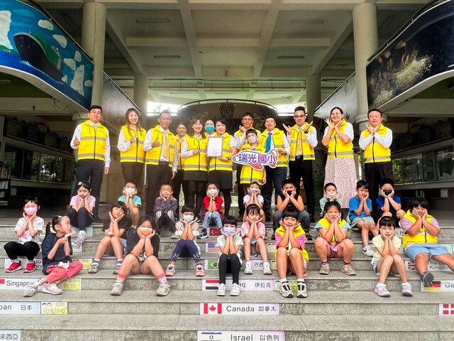 永慶房產集團屏東區四品牌經管會長鄭景鴻(後排左3)代表捐贈導護背心給屏東瑞光國小，全力守護孩童與導護人員。