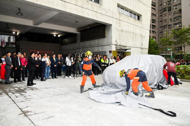 在捐贈現場中，消防人員親自示範如何用滅火毯快速撲滅電動車起火，讓災害降到最低點(永慶房產集團提供)